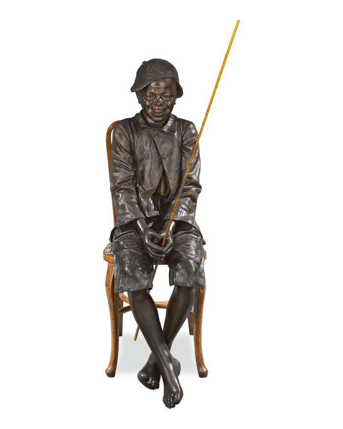 This enchanting sculpture depicts a charming genre scene of a young boy fishing